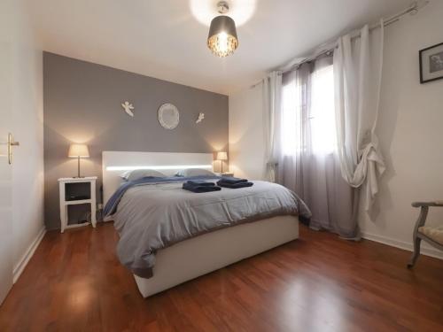 ein Schlafzimmer mit einem großen Bett und einem Fenster in der Unterkunft TEA&CHILL- Les Bluets - house with 2 terraces in Noisy-le-Sec