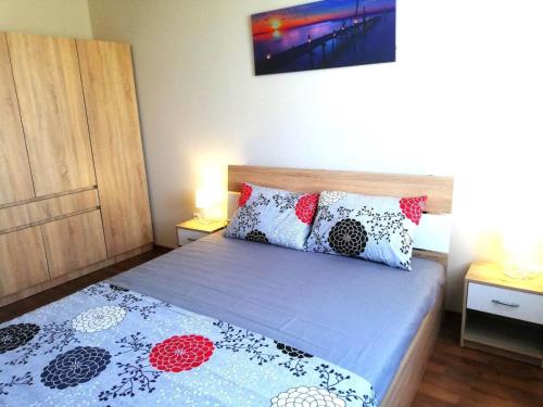 a bedroom with a bed with two pillows on it at Апартамент Sunny home in Chernomorets