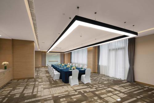a conference room with a long table and white chairs at Holiday Inn Chengdu Airport by IHG - Free Shuttle to Shuangliu International Airport in Chengdu