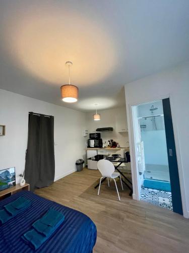 une chambre avec un lit, une table et une chaise dans l'établissement Appartement cosy proche gare Angers, à Angers