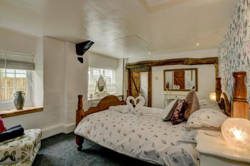 ein Schlafzimmer mit einem großen Bett und einem Spiegel in der Unterkunft Hartford Cottage West Anstey in East Anstey