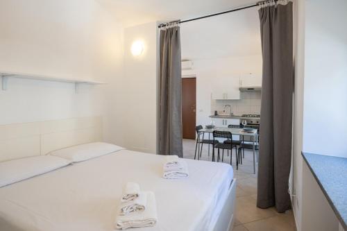 um quarto com uma cama branca e uma cozinha em Dolce Rifugio, base Ideale per Esplorare la Città em Turim