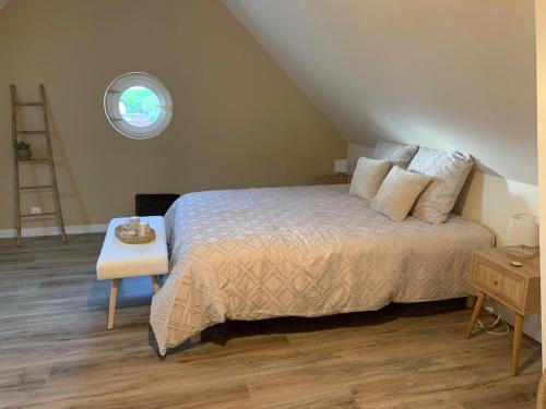Margon的住宿－Les chambres de Christelle & Gilbert，一间卧室设有一张床和一个圆形的窗户。