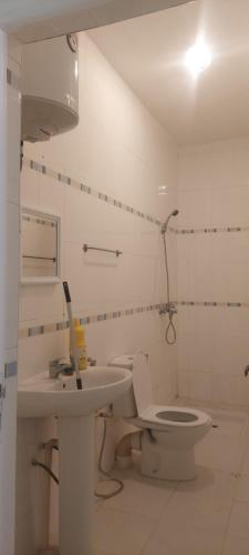 a white bathroom with a toilet and a sink at Villa bien equiper a saidia pres de la plage in Saïdia
