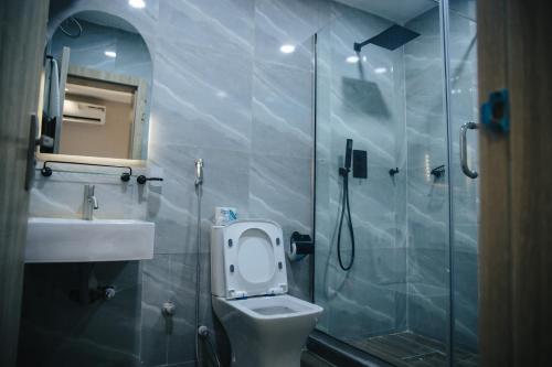 a bathroom with a shower and a toilet and a sink at DE LEVERAGE HOTEL & SUITES in Lagos