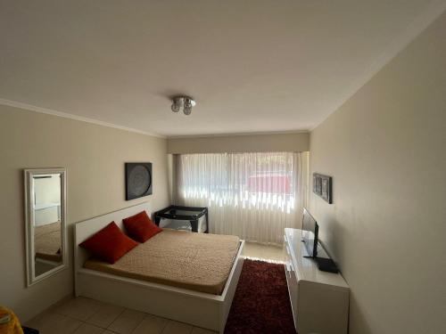 una camera da letto con un letto con cuscini rossi e uno specchio di Eden Residence a Cannes