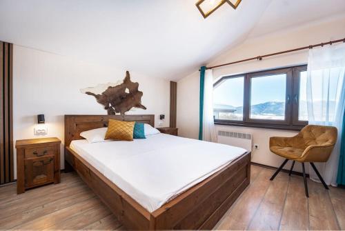 バンスコにあるPrivate cozy at Alpin Lodge Studio + SPA Complexの大きなベッドと椅子のある寝室