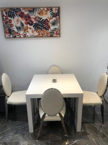 une table avec quatre chaises et une table blanche dans l'établissement 3 pièces 2 SDB centre de Cannes, à Cannes