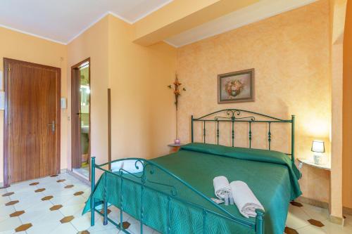 ジャルディーニ・ナクソスにあるVilla Cavallaroのベッドルーム1室(緑色のベッド1台、タオル付)