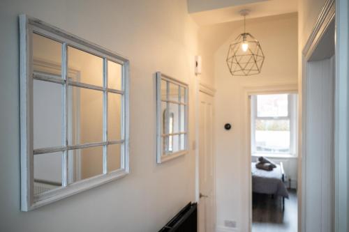 a hallway with a window and a pendant light at Whitley Haven, Luxury Seaside Apartment in Whitley Bay