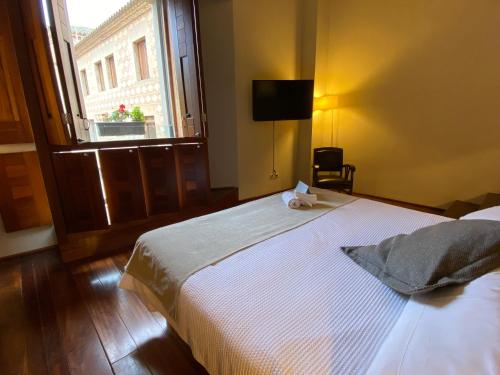 a bedroom with a large white bed with a window at Hostatgeria de Poblet in Poblet