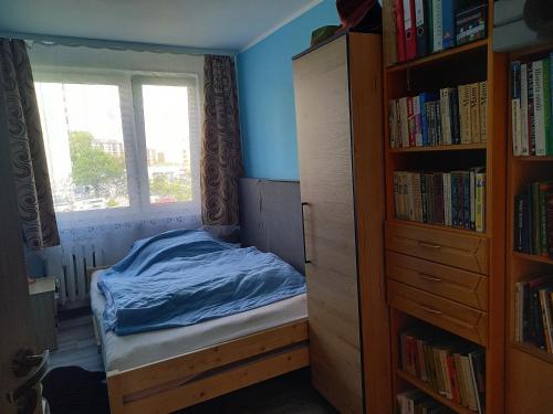 a small bedroom with a bed and a book shelf at zwykłe mieszkanie dla zwykłych ludzi in Wałbrzych