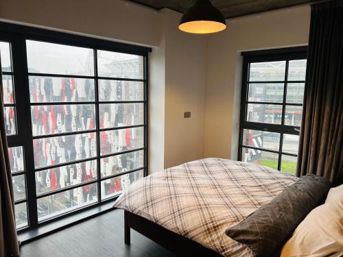 a bedroom with large windows and a bed in front of it at Homely 2-Bed Apartment with stunning Views Wembley in London