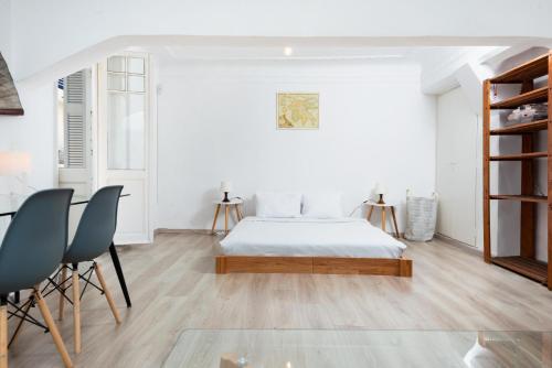 Schlafzimmer mit einem Bett, einem Tisch und Stühlen in der Unterkunft Beautiful Neo-Classic apartment in Exarchia (1Bed) in Athen