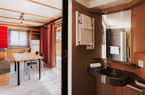a bathroom with a sink and a table in a room at Camping Cala Pola in Tossa de Mar