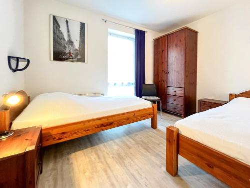 1 dormitorio con 2 camas y ventana en Dünenblick Wohnung 38, en Boltenhagen