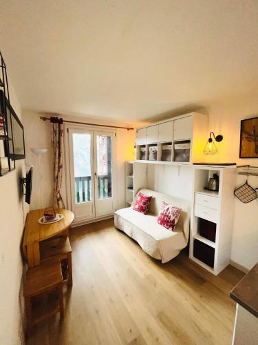 um quarto com uma cama, uma secretária e uma janela em Studio station Puy-Saint-Vincent 1700 em Puy-Saint-Vincent