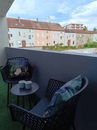 d'un balcon avec une table, deux chaises et une table. dans l'établissement Appartement proche du centre, à Mulhouse
