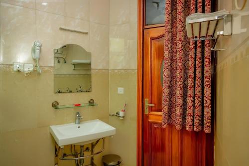 baño con lavabo y puerta roja en Home Inn Hotel Rwanda, en Ruhengeri