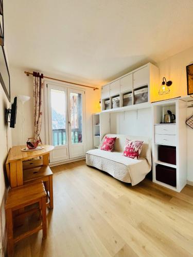 um quarto com uma cama, uma secretária e uma janela em Studio station Puy-Saint-Vincent 1700 em Puy-Saint-Vincent