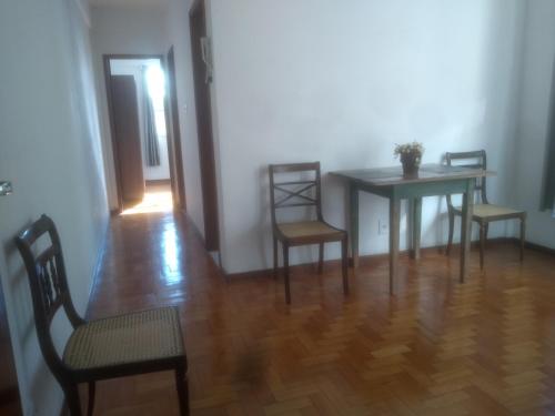 a dining room with a table and two chairs and a table at Apartamento Jardim Cascata in Teresópolis