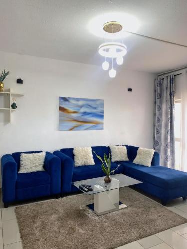 a living room with a blue couch and a table at Appartement 1 chambre, 1 salon, 1 balcon, Immeuble T Bella, Calafatas, Yaoundé in Yaoundé