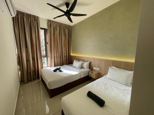 a hotel room with two beds and a ceiling fan at Bali Premier Suites Melaka in Melaka