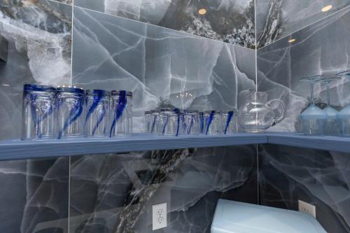 ein Regal mit blauen Glasgegenständen darauf in der Unterkunft Lavish Blue Suite 5 with Hollyhock in Louisville