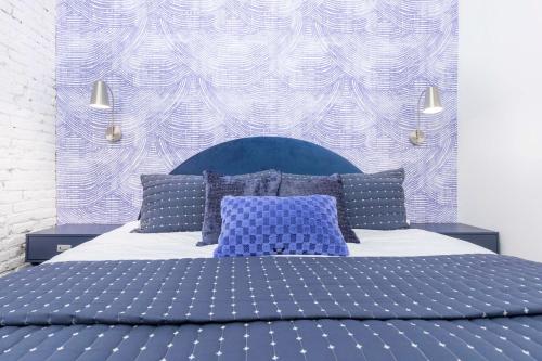 Un dormitorio con una cama azul y blanca con almohadas en Lavish Blue Suite 5 with Hollyhock, en Louisville