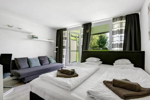 sala de estar con 2 camas y sofá en Ferienappartement Schmetterling, en Sankt Englmar