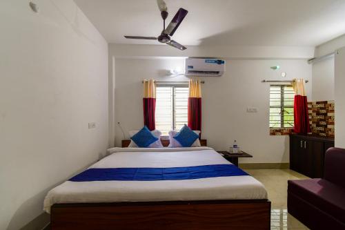 a bedroom with a large bed with blue pillows at Eden Hotel in kolkata