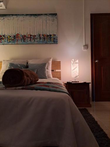 a bedroom with a bed and a lamp on a table at Kensington Cozy Apartment in Flic-en-Flac