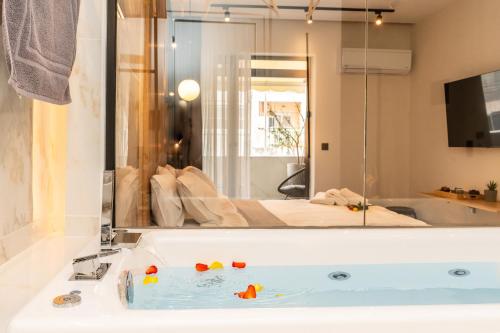 a bathroom with a tub with a bed in a mirror at Mini luxury suites by Sea&theCity in Thessaloniki