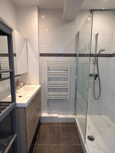 une salle de bain blanche avec une douche et un lavabo dans l'établissement Quartier BRUNET appartement agréable bien équipé., à Toulon