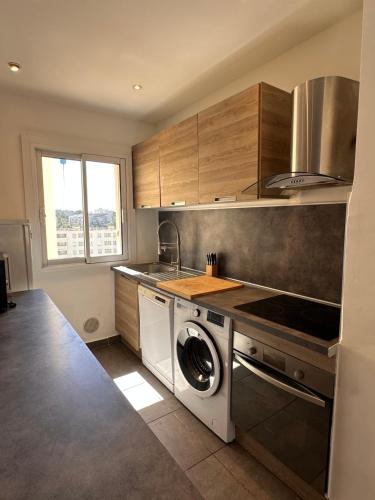 une cuisine avec une machine à laver et un évier dans l'établissement Quartier BRUNET appartement agréable bien équipé., à Toulon