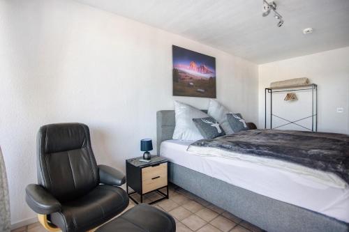 ein Schlafzimmer mit einem Bett und einem Stuhl in der Unterkunft The View in Bad Reichenhall