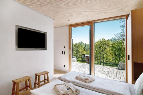 a bedroom with two beds and a flat screen tv at Bodensee Oberschwaben in Horgenzell