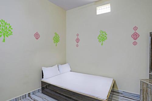 SPOT ON SKP Hotel في Chimur: غرفة مع مقعد أبيض والنباتات على الحائط