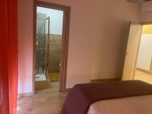 ein Schlafzimmer mit einem Bett und ein Badezimmer mit einer Dusche in der Unterkunft B&B Aeroporto in Azzano San Paolo