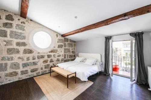 una camera da letto con un muro in pietra e un letto di Stunning 13th Century Luxury Villa* Garden & Pool ad Ávila