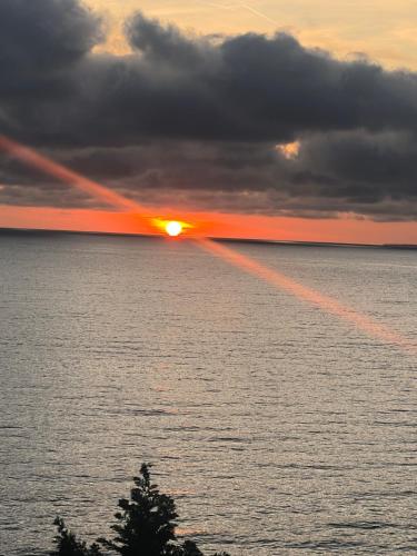 a sunset over a body of water with the sun at Holiday season at sea in Shëngjin