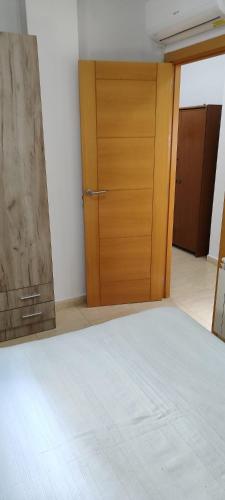a bedroom with a bed and a wooden door at Jesús Del Perdón in Manzanares