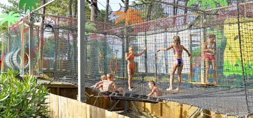 un grupo de niños en una jaula de bateo en un parque acuático en Camping Kévano Plage en Pianottoli-Caldarello