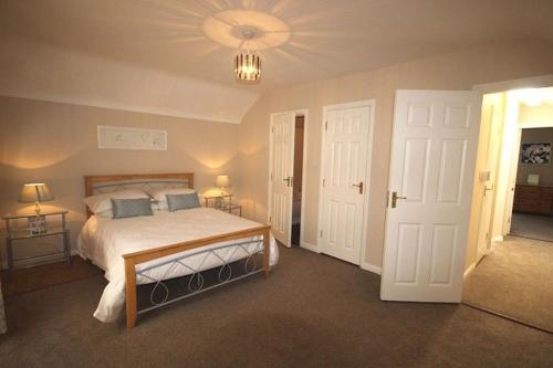 a bedroom with a bed and a chandelier at 2 Clifden Court in Clifden