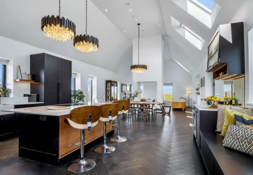 a kitchen and living room with a bar and chairs at Sweet Garden, Mannin - Ballyconneely in Ballyconneely