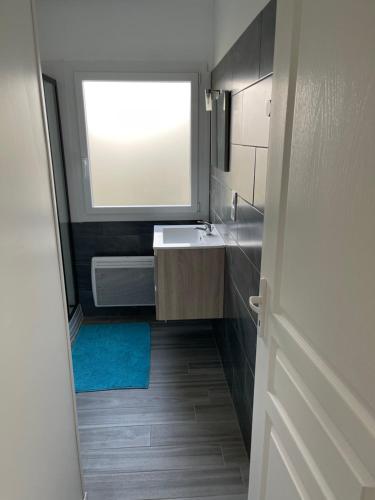 une petite salle de bain avec un lavabo et une fenêtre dans l'établissement Rapas, à Erdeven