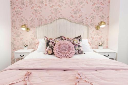 a pink bedroom with a large bed with a pink flower pillow at Kentucky Princess Pretty in Pink in Louisville