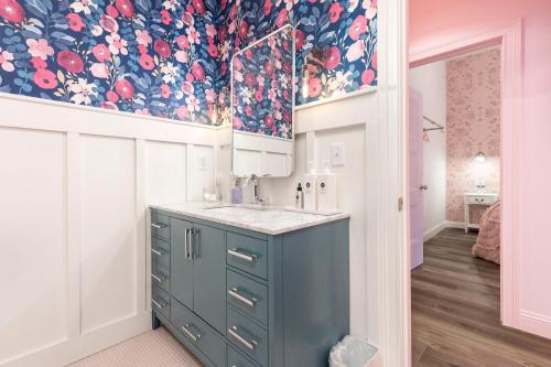 a kitchen with a blue cabinet and a floral wallpaper at Kentucky Princess Pretty in Pink in Louisville