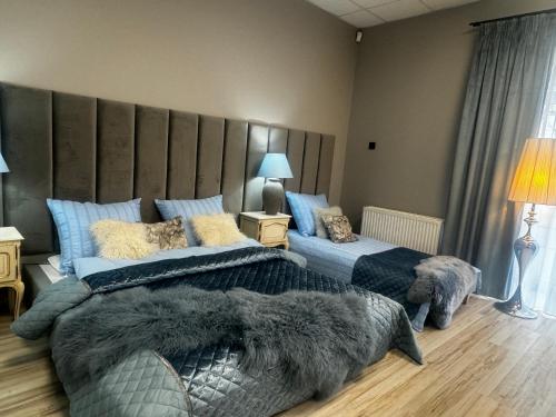 um quarto com 2 camas e uma grande cabeceira em Apartamenty i pokoje „Pod Jedynką” em Konstantynów Lódzki