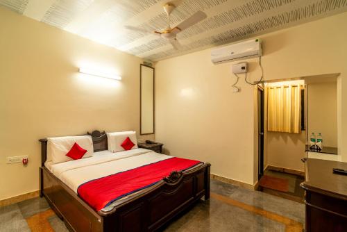 a bedroom with a bed with a red blanket at The Venue By Seasons Suites- in Dod Ballāpur